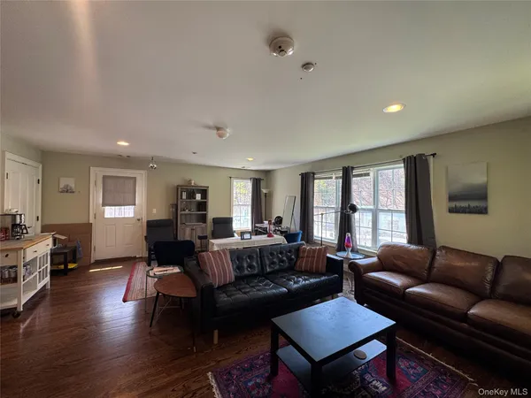 a living room with furniture wooden floor and a window
