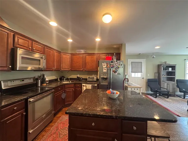 a kitchen with stainless steel appliances granite countertop a sink a stove and a microwave