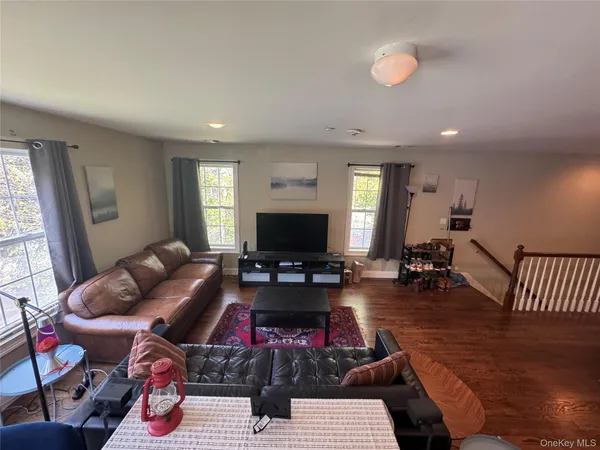 a living room with furniture a flat screen tv and a large window