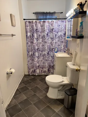 a bathroom with a toilet and a shower curtain