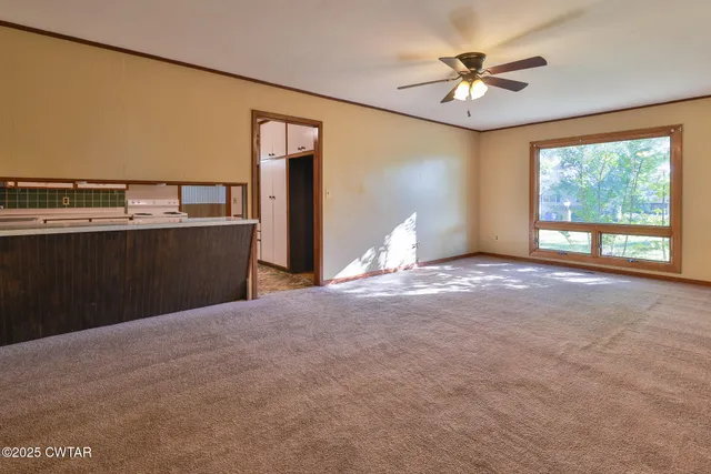 a view of a livingroom with a ceiling fan and window
