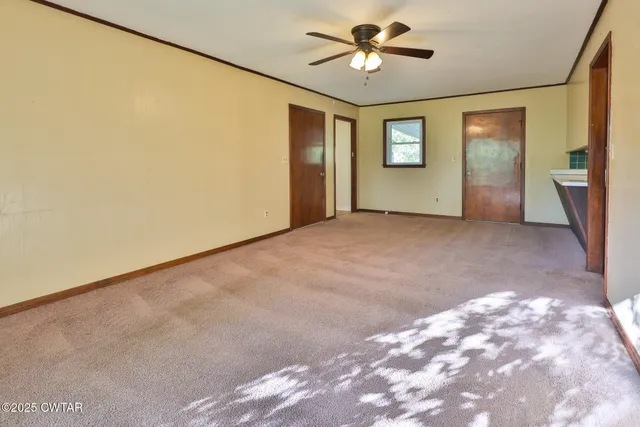 a view of a big room with wooden floor and windows