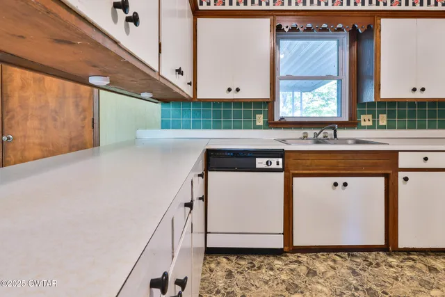 a kitchen with stainless steel appliances granite countertop a sink and a microwave