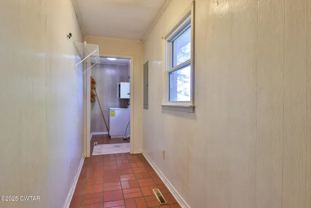 a view of a hallway with wooden floor and a bathroom