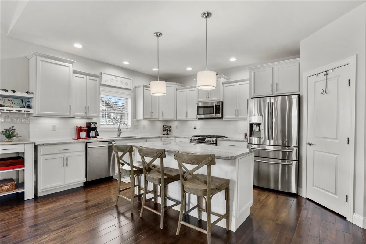 1604 Kassen Avenue Mahomet, IL 61853 - Photo 7 of 35 a kitchen with kitchen island white cabinets and stainless steel appliances