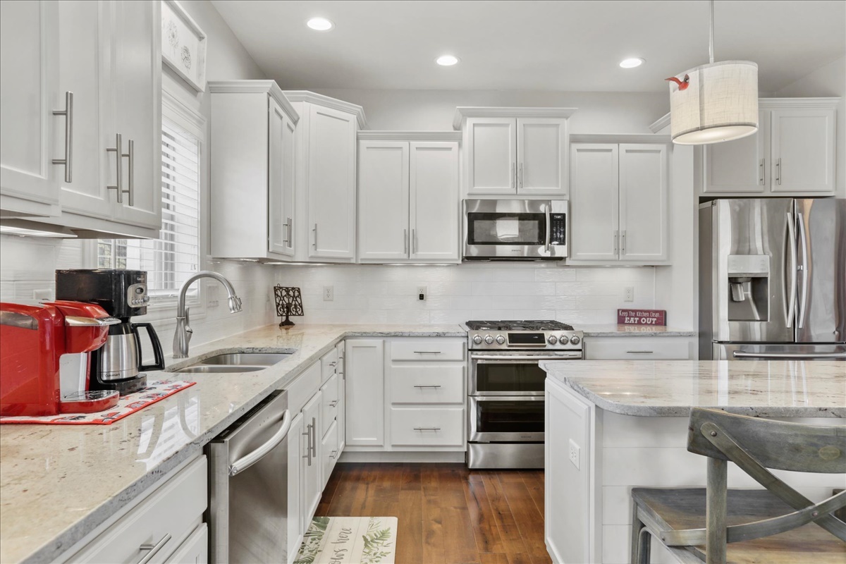 1604 Kassen Avenue Mahomet, IL 61853 - Photo 8 of 35 a kitchen with stainless steel appliances granite countertop a stove top oven a sink and white cabinets