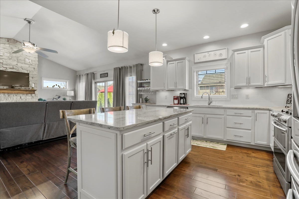 1604 Kassen Avenue Mahomet, IL 61853 - Photo 9 of 35 a kitchen with stainless steel appliances granite countertop a sink a stove top oven a counter space and cabinets