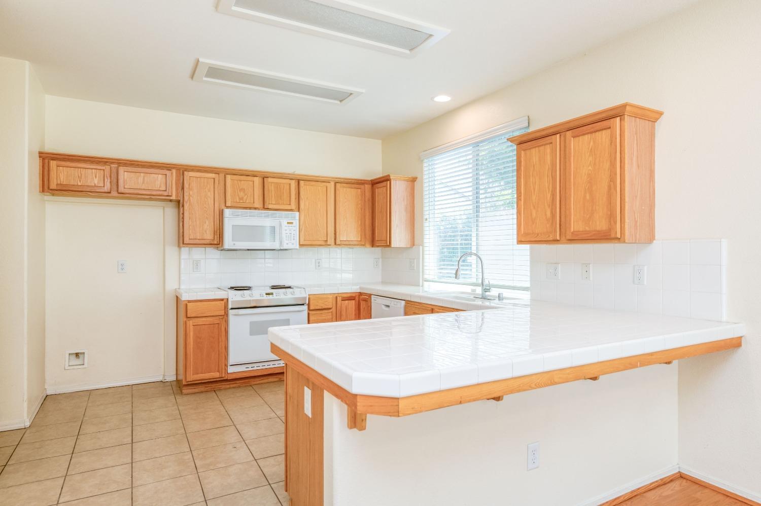 694 West Lisbon Lane Clovis, CA 93619 - Photo 12 of 39 a kitchen with stainless steel appliances granite countertop a sink stove and refrigerator