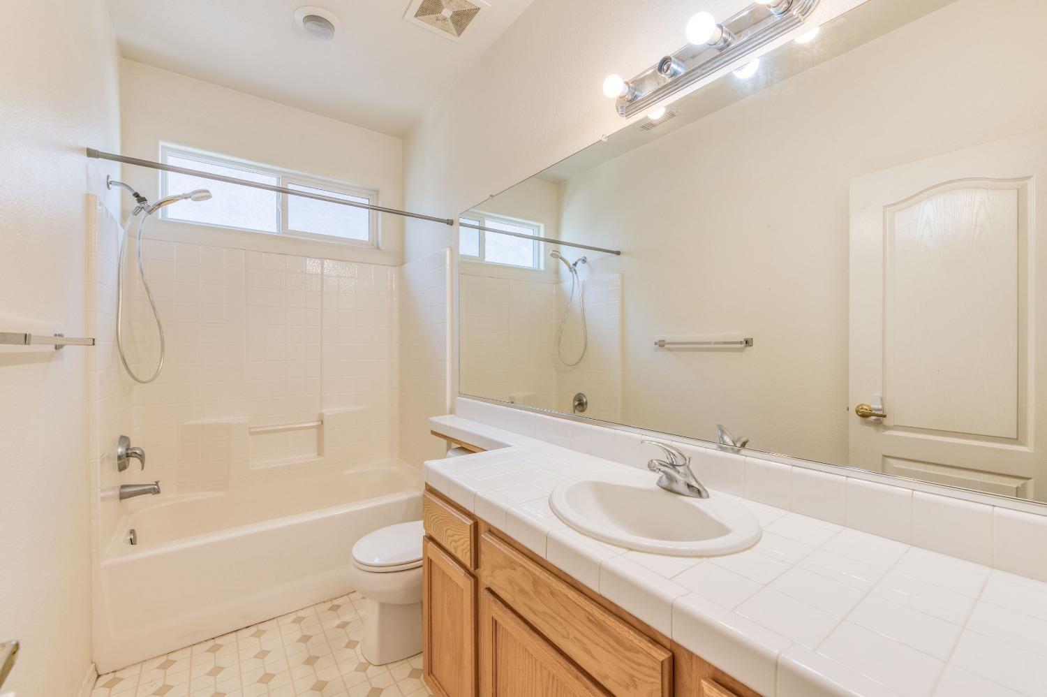 694 West Lisbon Lane Clovis, CA 93619 - Photo 17 of 39 a bathroom with a sink toilet tub and shower