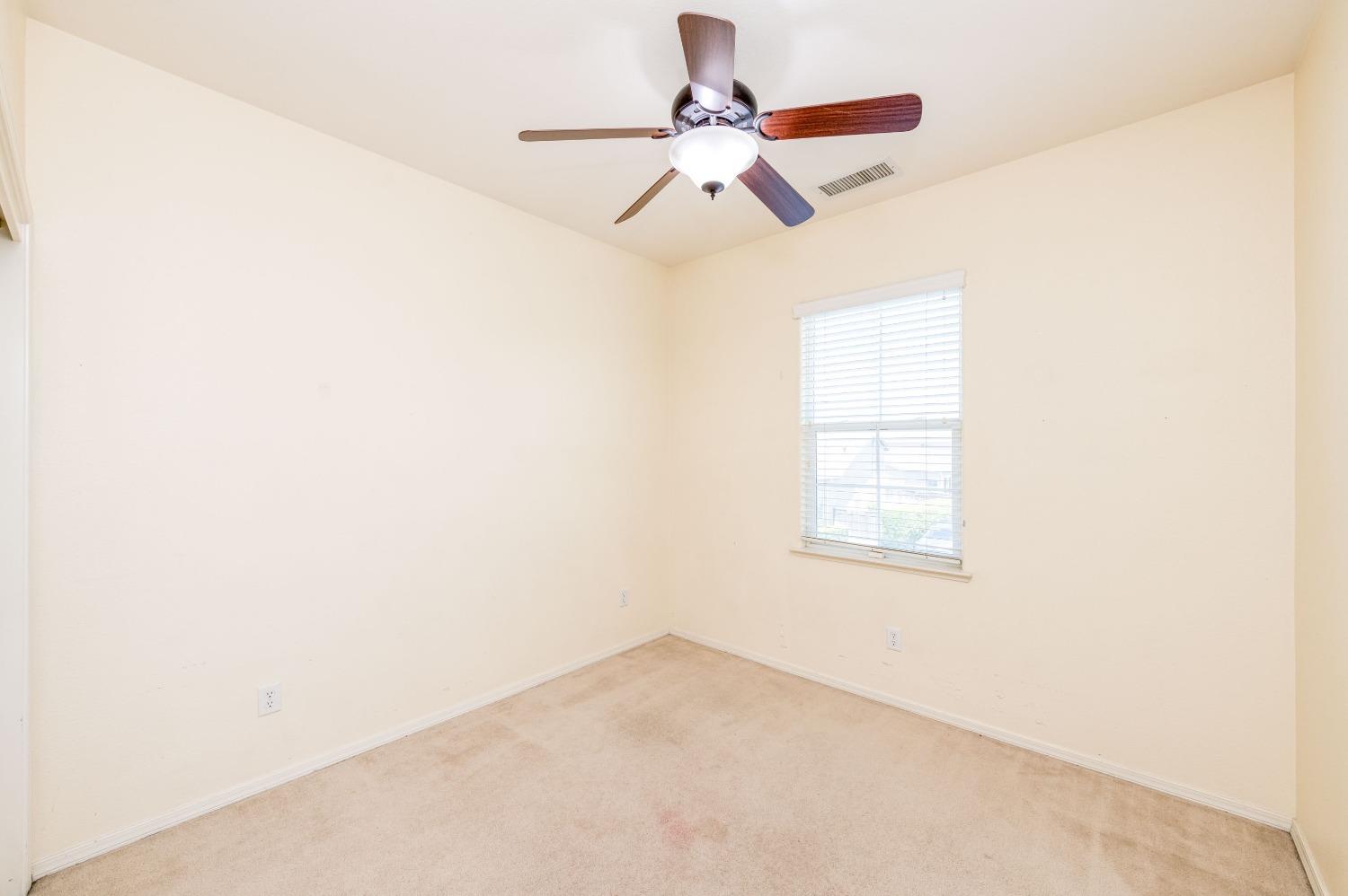 694 West Lisbon Lane Clovis, CA 93619 - Photo 19 of 39 an empty room with a window and a ceiling fan