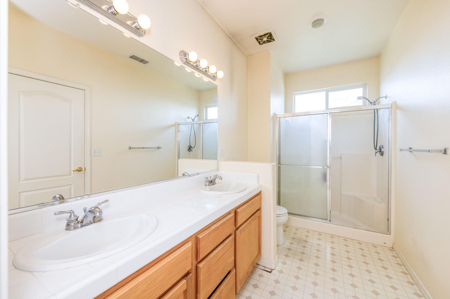 694 West Lisbon Lane Clovis, CA 93619 - Photo 23 of 39 a bathroom with a double vanity sink mirror and shower