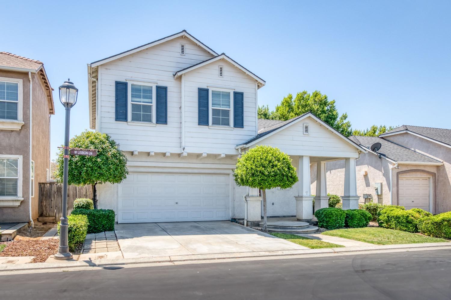 694 West Lisbon Lane Clovis, CA 93619 - Photo 36 of 39 a front view of a house with a yard and potted plants