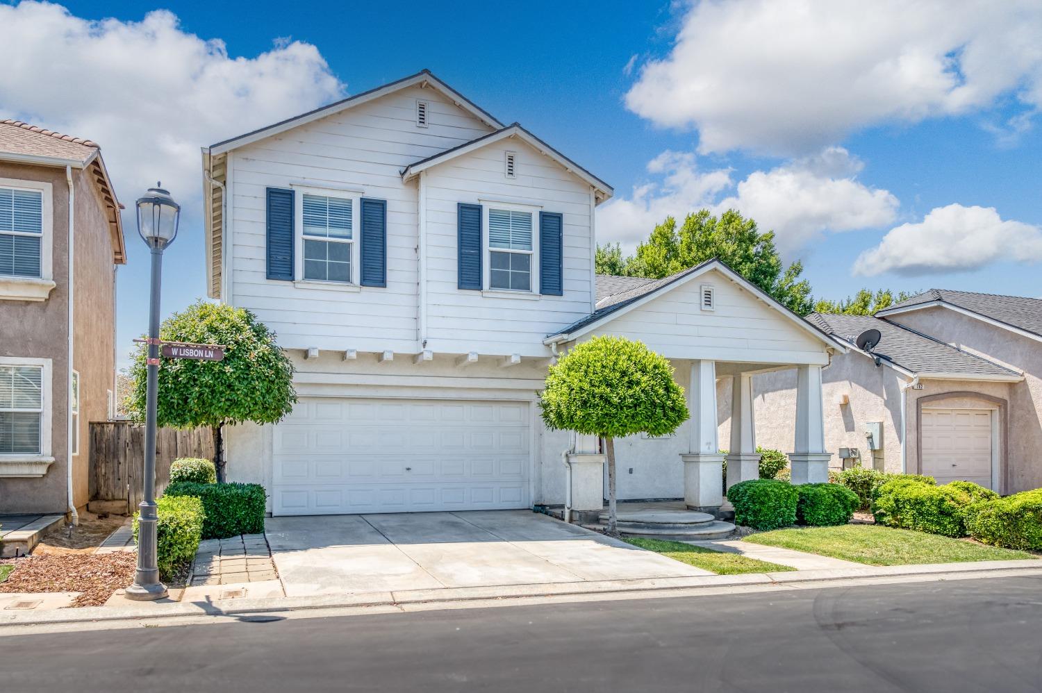 694 West Lisbon Lane Clovis, CA 93619 - Photo 37 of 39 a front view of a house with a yard and potted plants