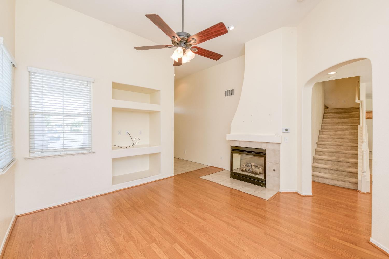 694 West Lisbon Lane Clovis, CA 93619 - Photo 6 of 39 a view of an empty room with a window and a kitchen