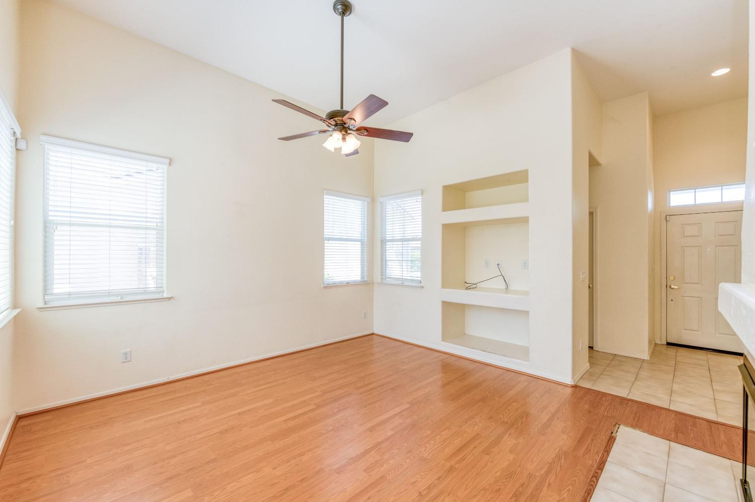 694 West Lisbon Lane Clovis, CA 93619 - Photo 7 of 39 a view of an empty room with a window and wooden floor