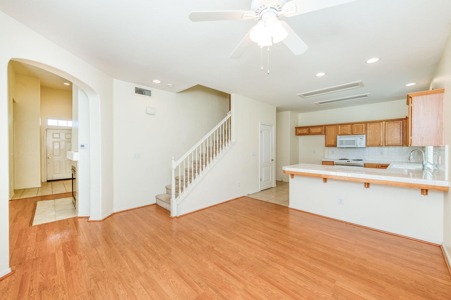 694 West Lisbon Lane Clovis, CA 93619 - Photo 10 of 39 a view of a kitchen with kitchen island a sink wooden floor and a living room