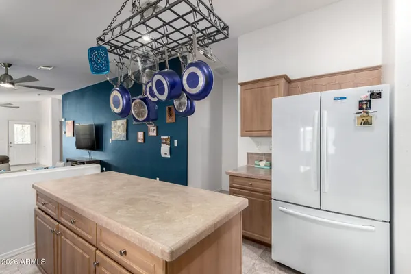 a kitchen with stainless steel appliances granite countertop a refrigerator a stove and a sink with chandelier