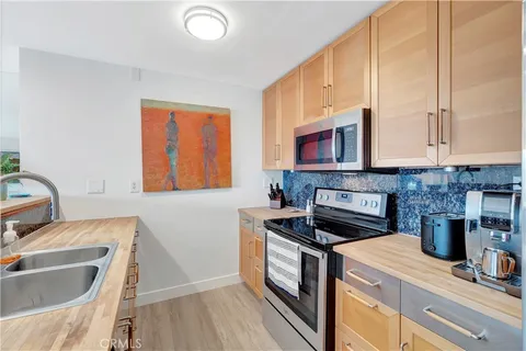 a living room with kitchen view and dining table with wooden floor