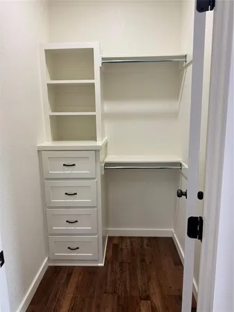 a view of walk in closet with empty racks