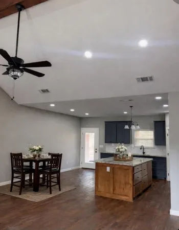a view of a kitchen with kitchen island table and chairs in it