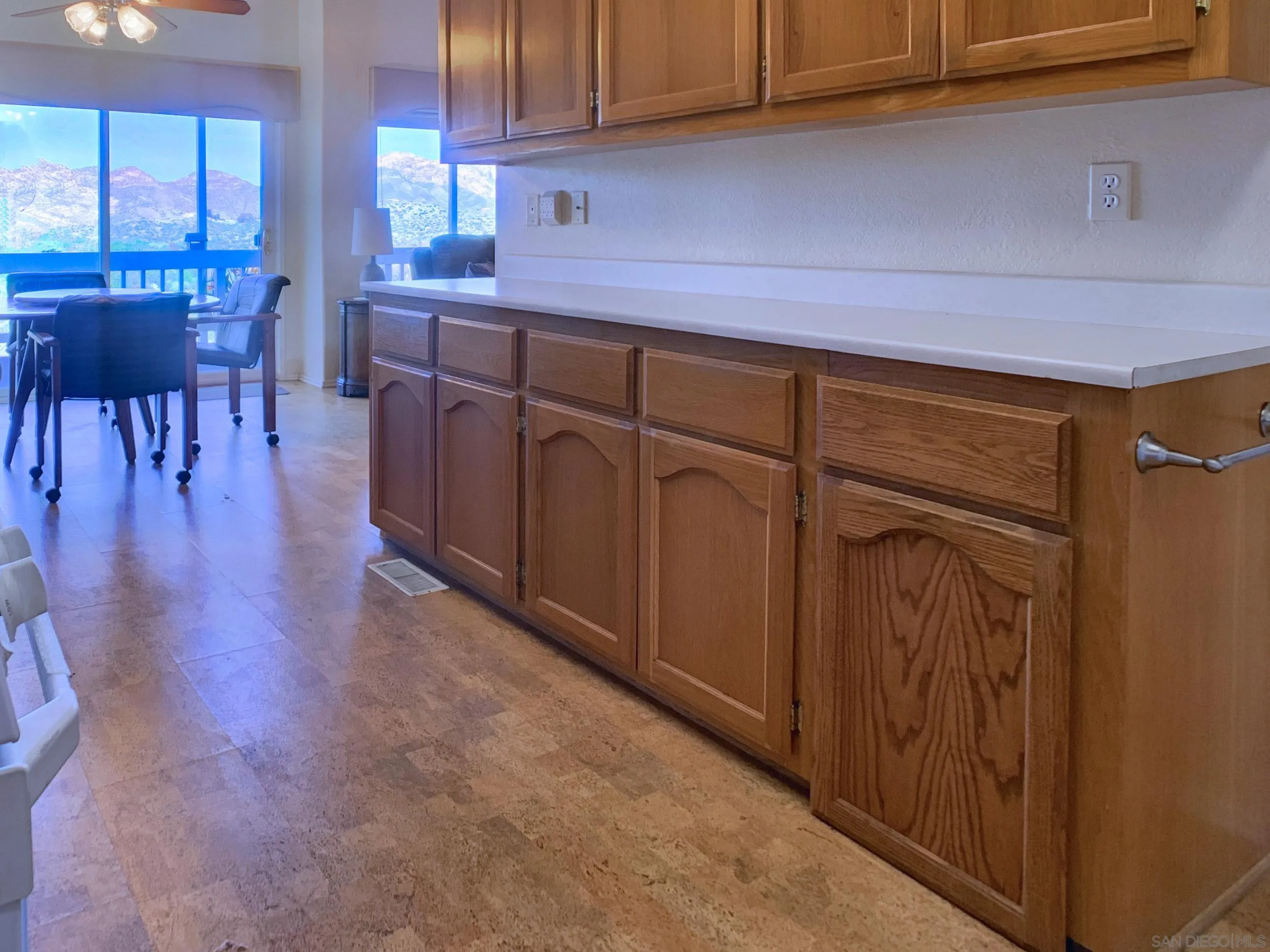 9500 Harritt Road, Unit SPC 25 Lakeside, CA 92040 - Photo 12 of 43 a kitchen with stainless steel appliances granite countertop a dishwasher a stove top oven a dining table and chairs with wooden floor