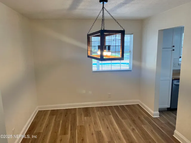 a view of a room with wooden floor and windows