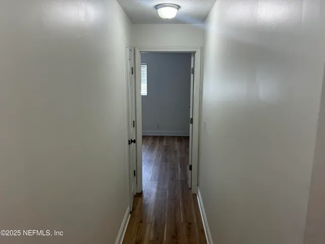 a view of a hallway with wooden floor