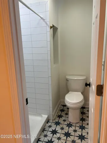 a bathroom with a toilet and a shower