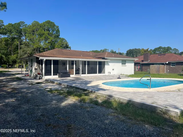a view of a white house with a large yard and large trees