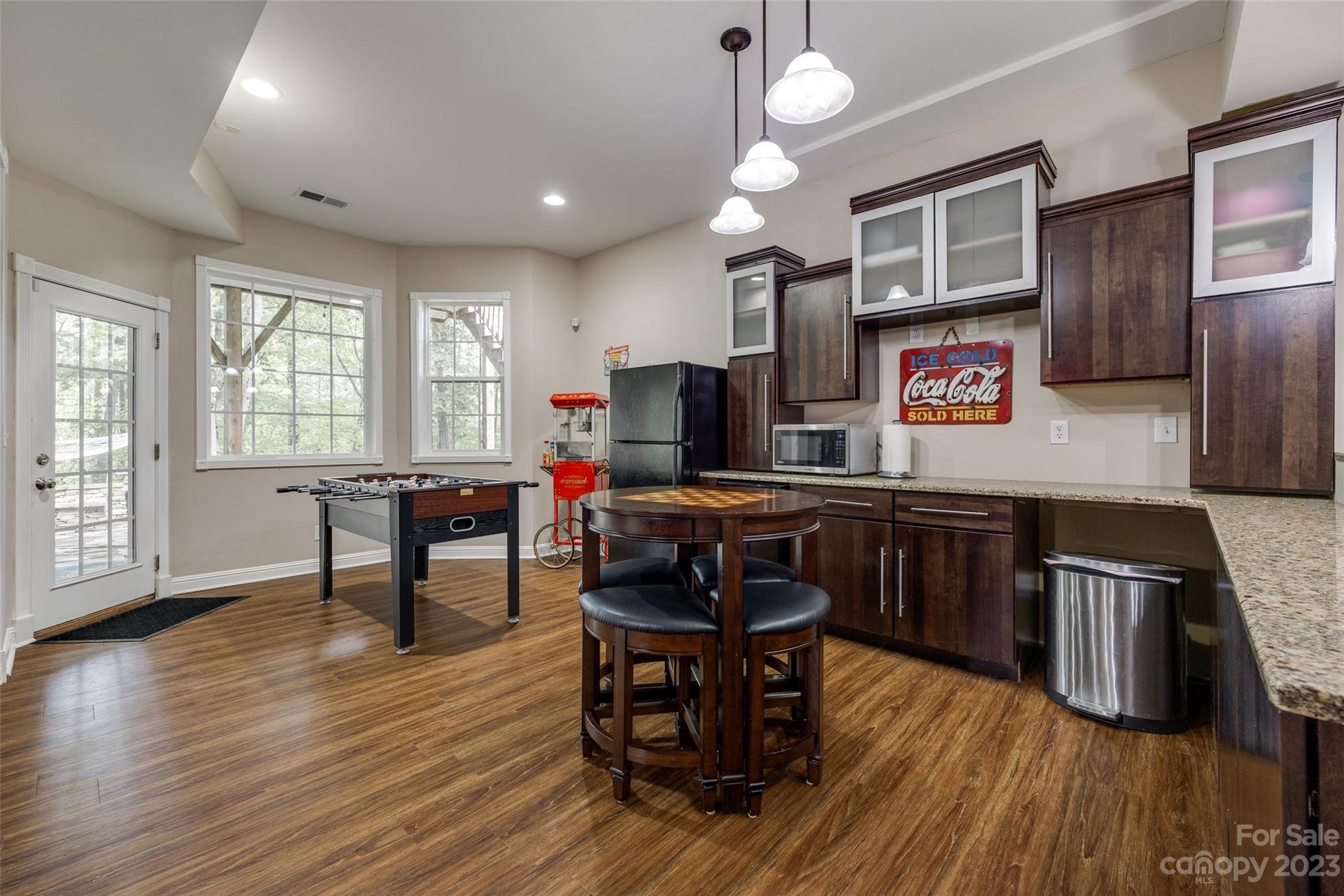 786 Fairway Point Drive Tega Cay, SC 29708 - Photo 26 of 39 a kitchen with stainless steel appliances granite countertop a stove top oven a dining table and chairs with wooden floor