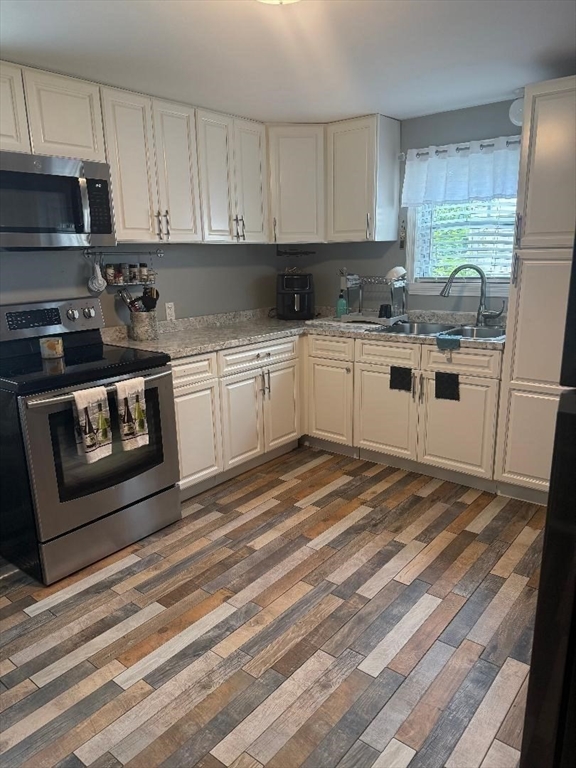 66 Powell Avenue Springfield, MA 01118 - Photo 10 of 31 a kitchen with stainless steel appliances granite countertop a stove a sink and a microwave