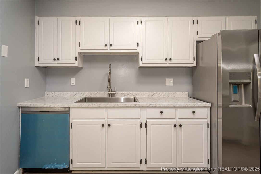4748 Old Spears Road Fayetteville, NC 28304 - Photo 15 of 37 a kitchen with granite countertop white cabinets and stainless steel appliances