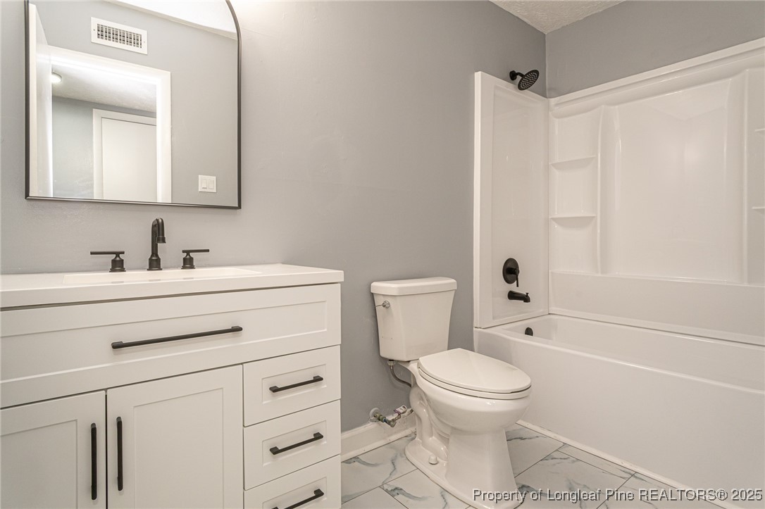 4748 Old Spears Road Fayetteville, NC 28304 - Photo 23 of 37 a bathroom with a sink a toilet and a mirror