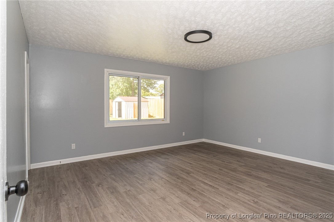 4748 Old Spears Road Fayetteville, NC 28304 - Photo 27 of 37 an empty room with wooden floor and windows