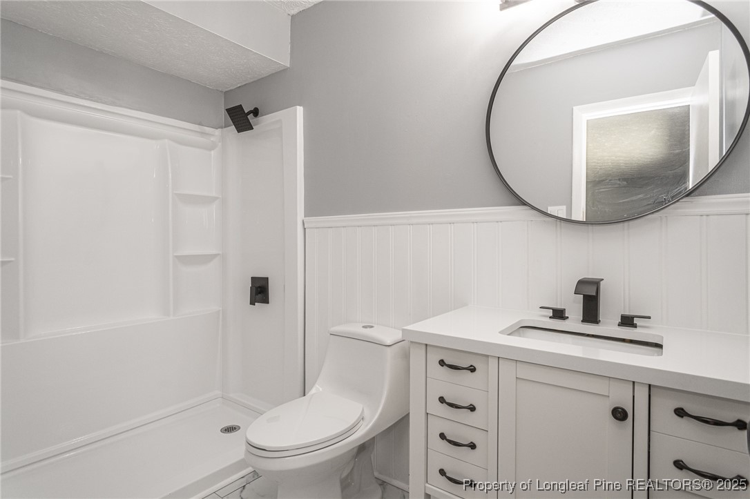 4748 Old Spears Road Fayetteville, NC 28304 - Photo 31 of 37 a bathroom with a sink a toilet and a mirror