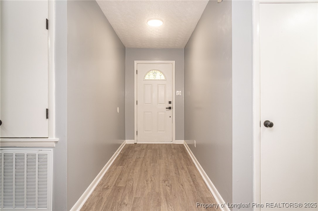4748 Old Spears Road Fayetteville, NC 28304 - Photo 4 of 37 a view of a hallway with wooden floor and a bathroom