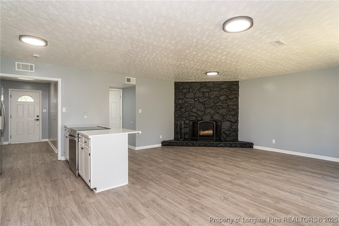 4748 Old Spears Road Fayetteville, NC 28304 - Photo 7 of 37 an empty room with wooden floor a fireplace and windows