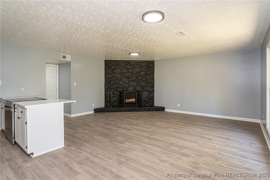 4748 Old Spears Road Fayetteville, NC 28304 - Photo 8 of 37 an empty room with wooden floor and fireplace