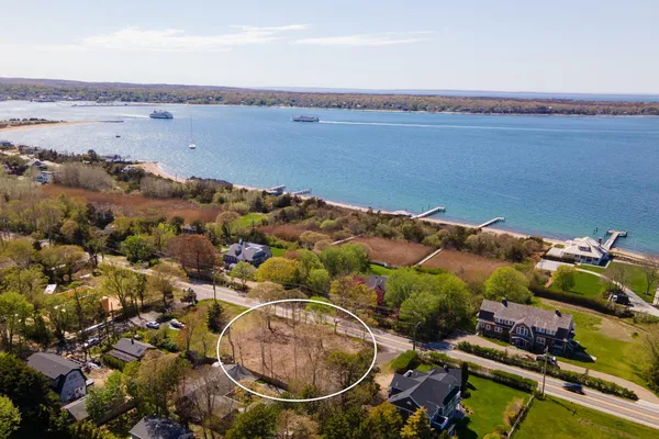 an aerial view of ocean and residential houses with outdoor space