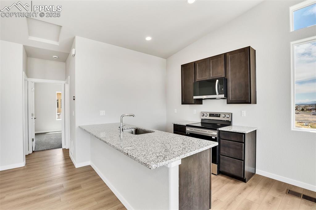 241 Front Street, Unit 101 Monument, CO 80132 - Photo 12 of 29 a kitchen with stainless steel appliances granite countertop a sink stove and refrigerator