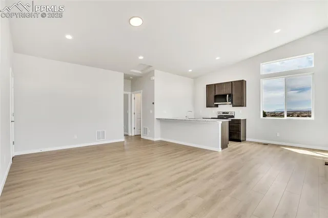 a view of kitchen with microwave oven a sink and a refrigerator