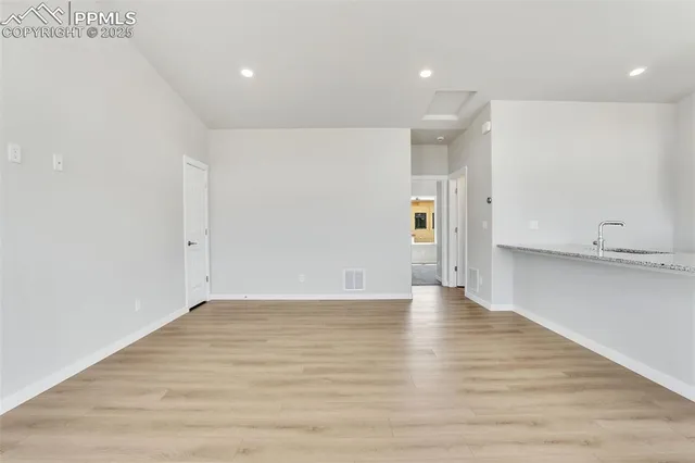 a view of an empty room with wooden floor
