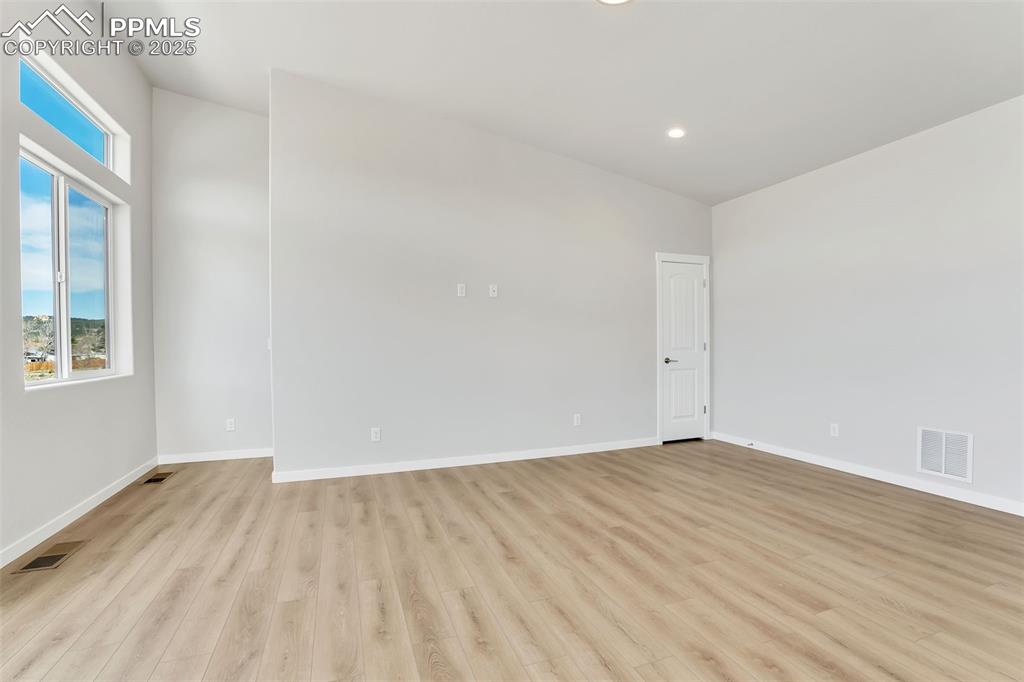 241 Front Street, Unit 101 Monument, CO 80132 - Photo 5 of 29 an empty room with wooden floor and windows