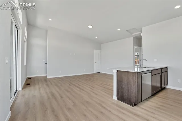 a view of kitchen with stainless steel appliances granite countertop cabinets and wooden floor