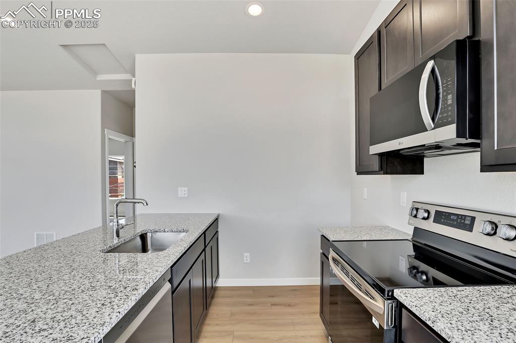 241 Front Street, Unit 101 Monument, CO 80132 - Photo 9 of 29 a kitchen with stainless steel appliances granite countertop a sink stove and refrigerator