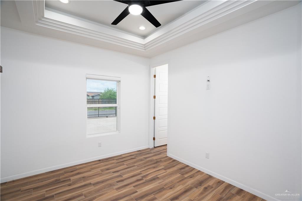 3018 Arrow Lane Weslaco, TX 78596 - Photo 12 of 22 an empty room with wooden floor and windows