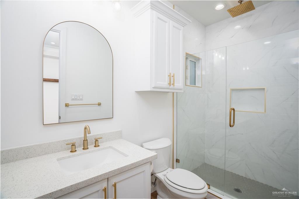 3018 Arrow Lane Weslaco, TX 78596 - Photo 13 of 22 a bathroom with a sink a toilet and a mirror