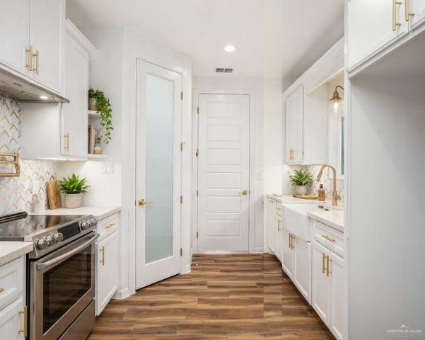 3018 Arrow Lane Weslaco, TX 78596 - Photo 6 of 22 a kitchen with white cabinets and stainless steel appliances