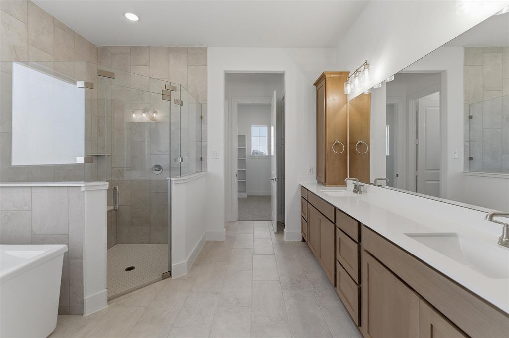 815 Vly Rdg Road Van Alstyne, TX 75495 - Photo 21 of 29 Spacious bathroom featuring a dual vanity with white countertops, light wood-finish cabinetry, and brushed nickel fixtures