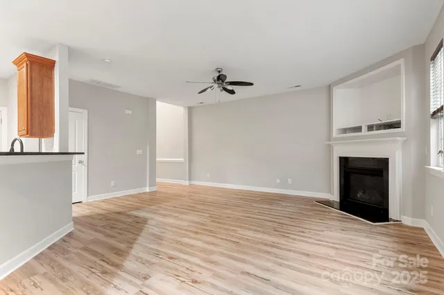 a view of empty room with a fireplace and wooden floor